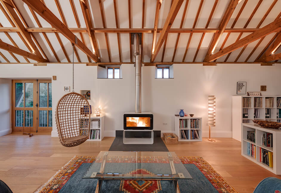 Barn Conversion Cornwall - Sitting room with log burner and lighting in eaves